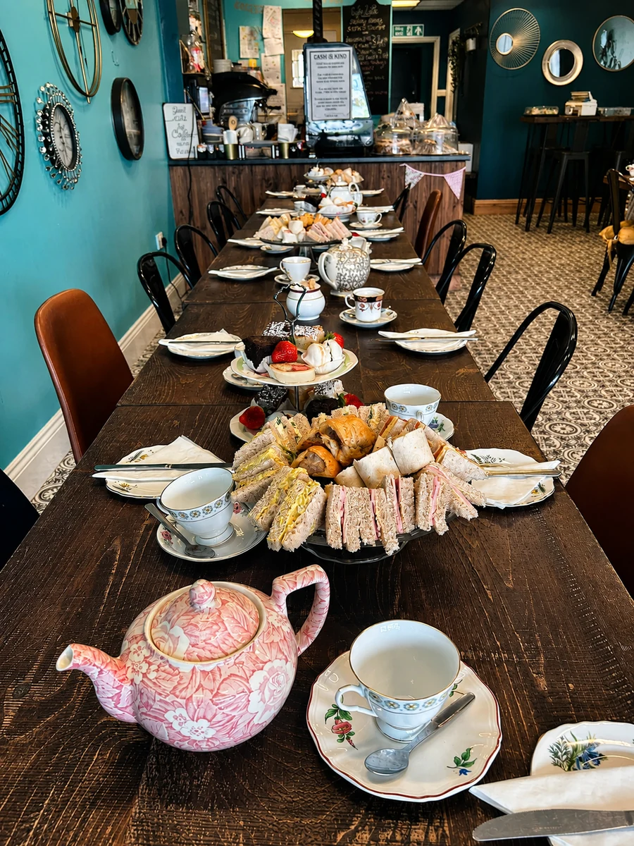 Cafe Latte dining room set for afternoon tea with sandwiches, cakes and teapots