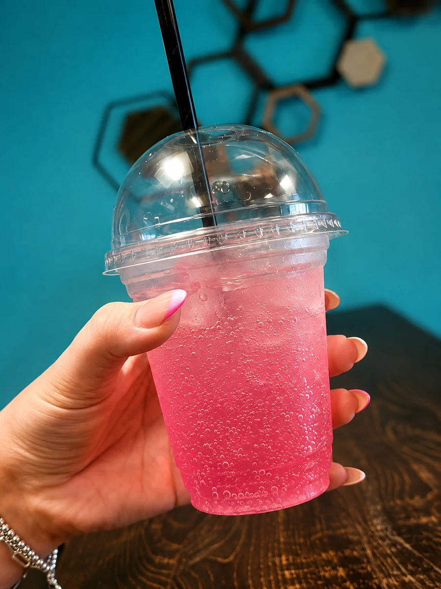A bright pink iced drink with a straw